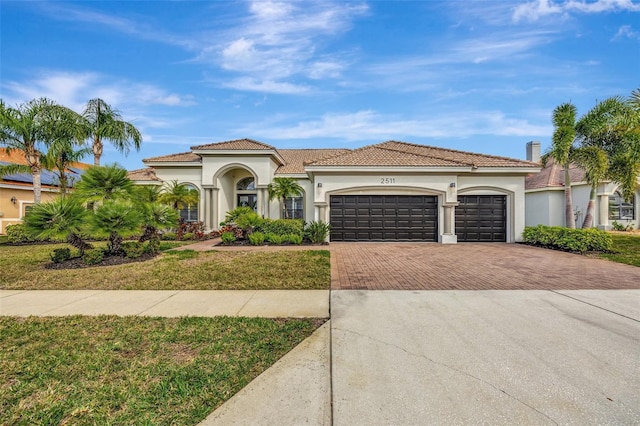 mediterranean / spanish-style house with a garage and a front yard