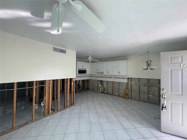 interior space with light tile patterned floors and ceiling fan