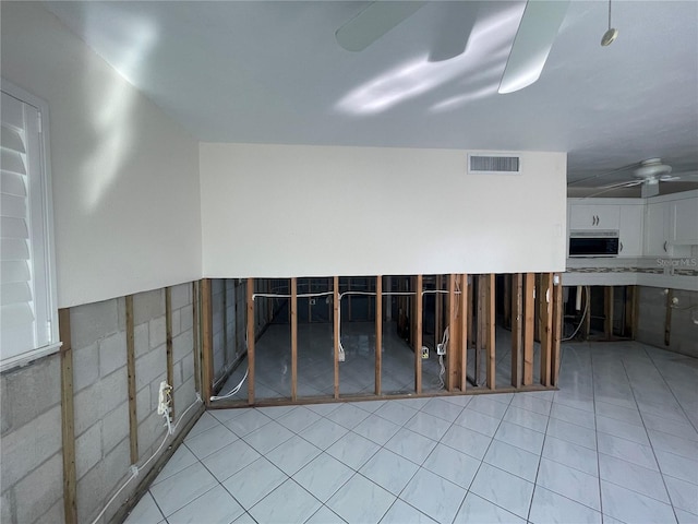 interior space with ceiling fan and light tile patterned floors