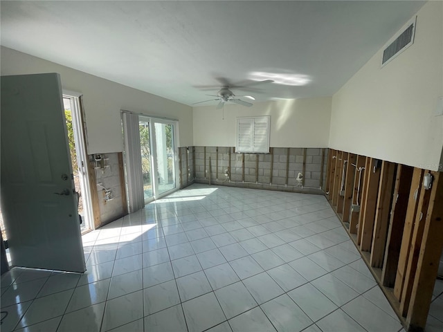 tiled empty room with tile walls and ceiling fan