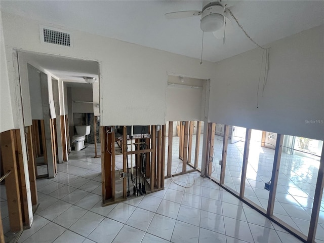 tiled empty room featuring ceiling fan