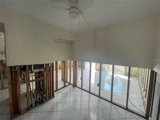 tiled spare room featuring ceiling fan