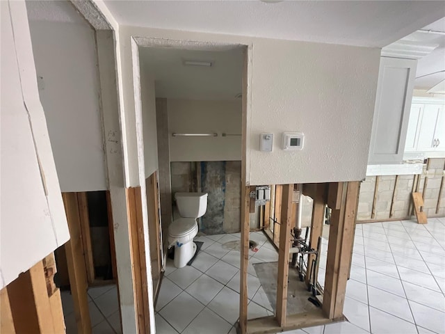 bathroom with toilet and tile patterned flooring