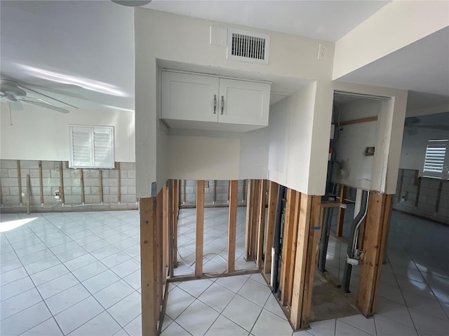 interior space featuring ceiling fan, white cabinets, and light tile patterned flooring