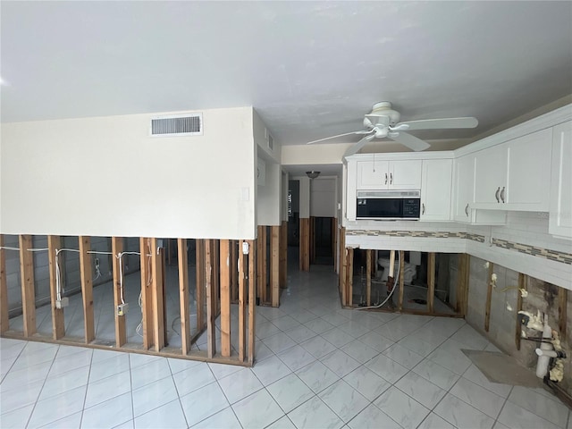 kitchen with white cabinetry, ceiling fan, decorative backsplash, and light tile patterned floors