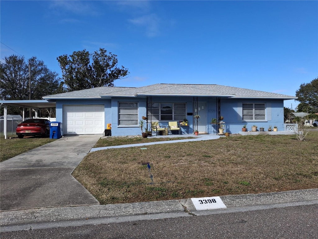 ranch-style house featuring a garage, a carport, and a front lawn