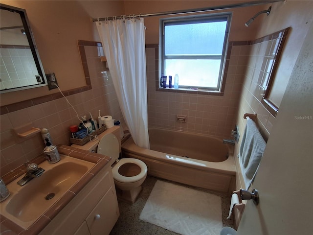 full bathroom featuring shower / bath combo with shower curtain, vanity, toilet, and tile walls