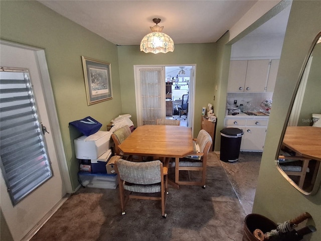 dining space featuring dark carpet