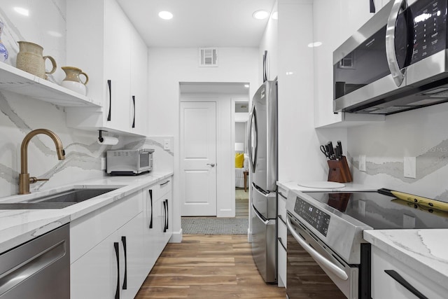 1200 N Shore Dr NE Unit 204, Saint Petersburg, FL 33701 - kitchen with white cabinets, stainless steel appliances, visible vents, and a sink