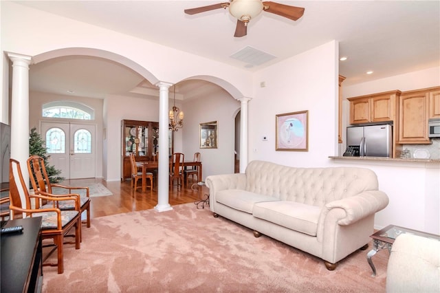 living room with ceiling fan, light wood-type flooring, and ornate columns