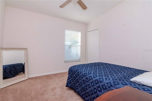 bedroom with vaulted ceiling, a closet, ceiling fan, and carpet