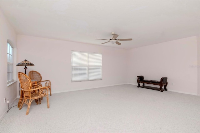 living area with carpet flooring and ceiling fan