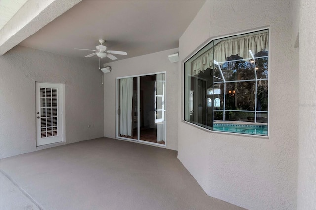 view of patio with an AC wall unit and ceiling fan