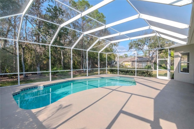 view of pool with a patio and glass enclosure