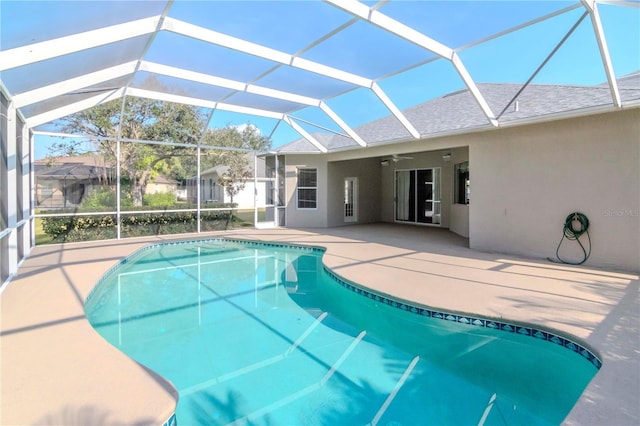 view of pool with a patio, ceiling fan, and glass enclosure