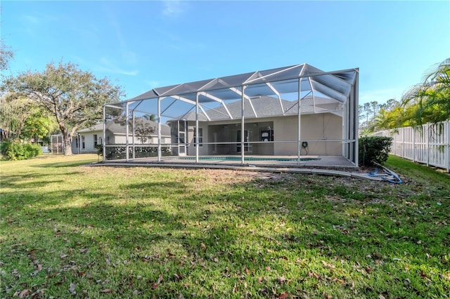 rear view of house featuring a fenced in pool, a lanai, and a yard