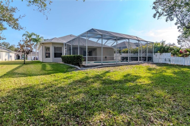 back of house with a fenced in pool, a lawn, and glass enclosure