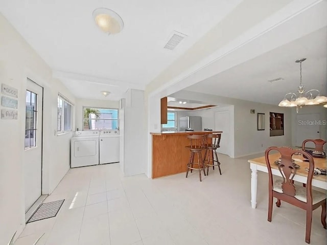 dining space featuring an inviting chandelier and washing machine and dryer