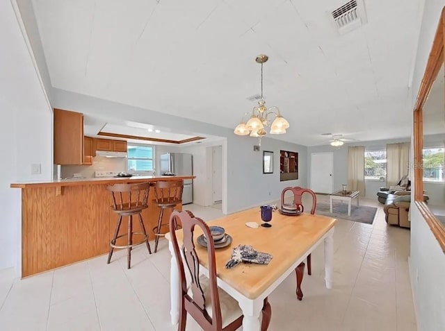 dining space featuring ceiling fan with notable chandelier and light tile patterned flooring