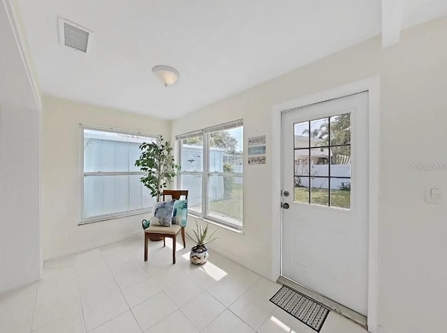 doorway to outside with light tile patterned flooring