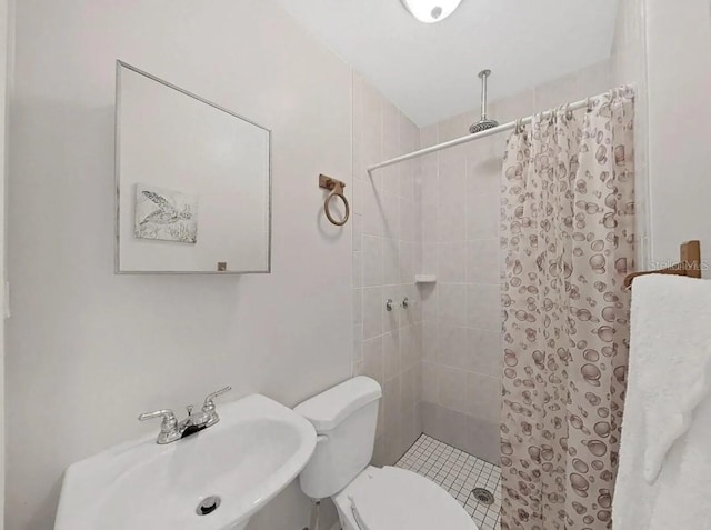 bathroom featuring toilet, sink, and tiled shower