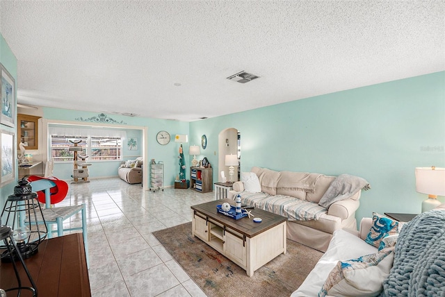 living room with light tile patterned flooring and a textured ceiling