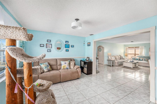 living room featuring light tile patterned floors and a textured ceiling