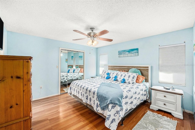 bedroom featuring ceiling fan, a textured ceiling, and light hardwood / wood-style floors