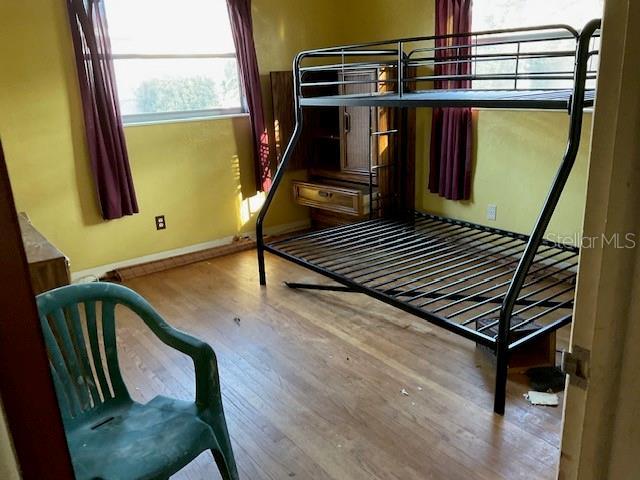 bedroom with wood finished floors and baseboards