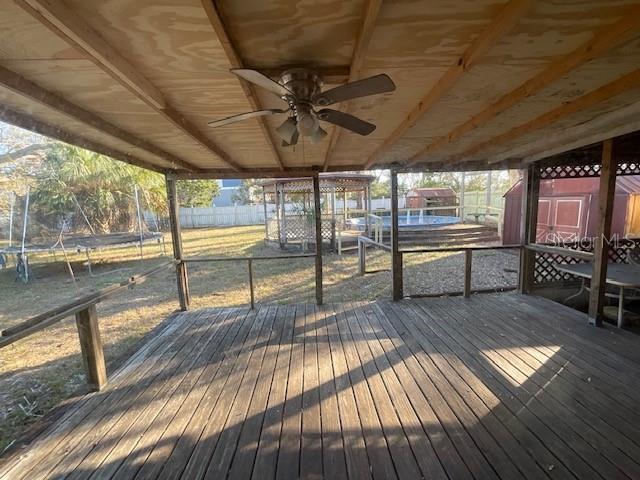 wooden terrace with fence and a ceiling fan