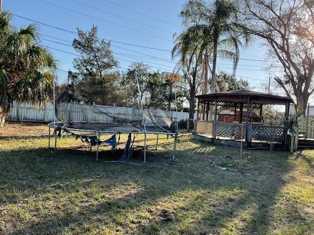 view of yard with a fenced backyard, a trampoline, and a gazebo