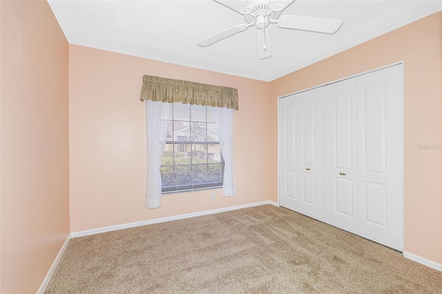 unfurnished bedroom featuring a closet, ceiling fan, and carpet flooring