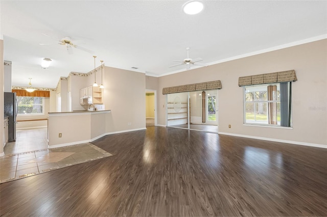 unfurnished living room with dark hardwood / wood-style flooring, crown molding, and ceiling fan