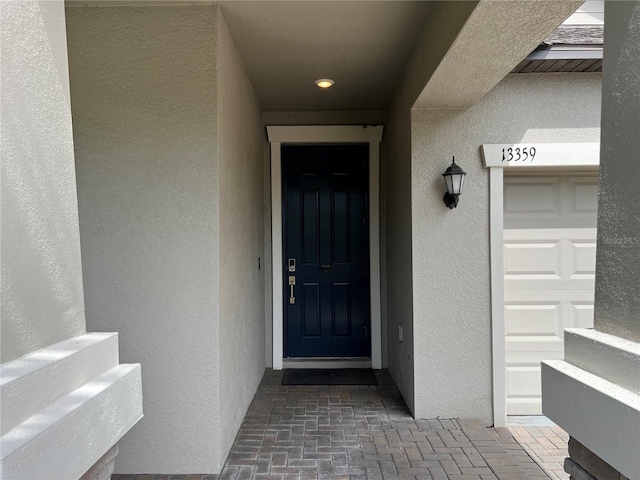 view of exterior entry featuring stucco siding