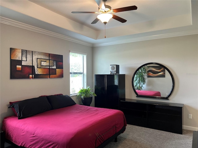 bedroom with a raised ceiling, carpet, a ceiling fan, and ornamental molding