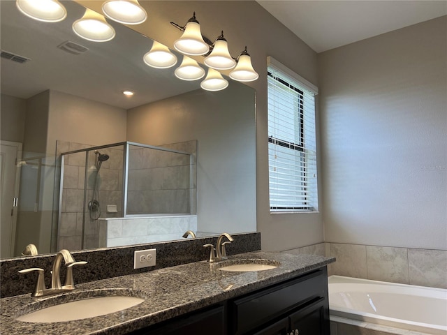 bathroom featuring visible vents, a sink, double vanity, and a stall shower