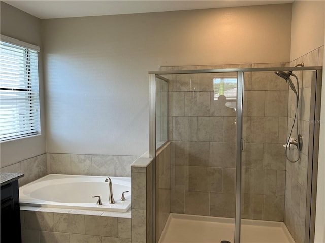 bathroom with a shower stall, a bath, and vanity