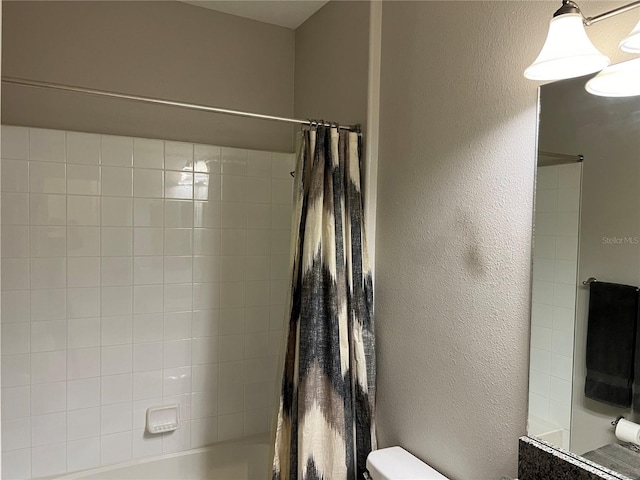 full bath with a textured wall, shower / bath combo, and toilet