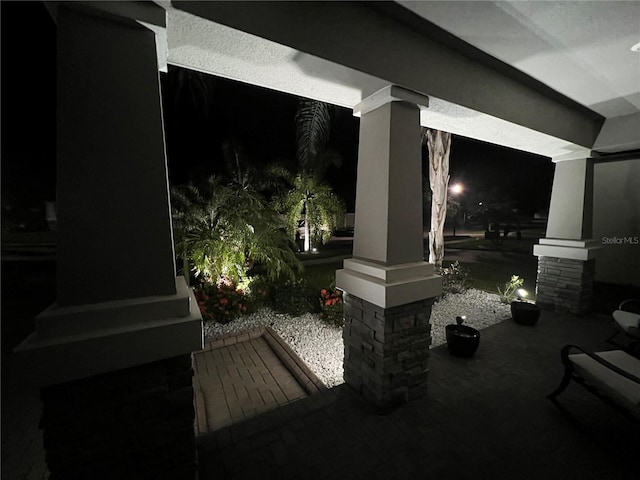 patio at twilight featuring covered porch