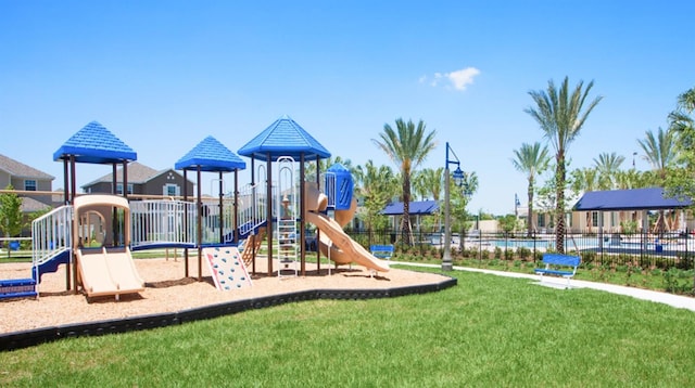 communal playground with fence and a lawn