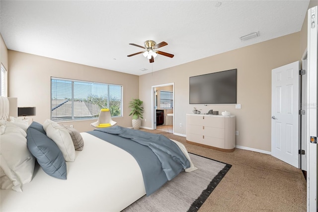 bedroom with ensuite bath, light colored carpet, and ceiling fan