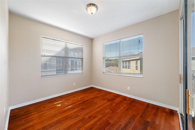 unfurnished room with dark hardwood / wood-style flooring