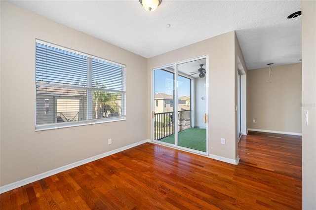 empty room with hardwood / wood-style floors and a textured ceiling