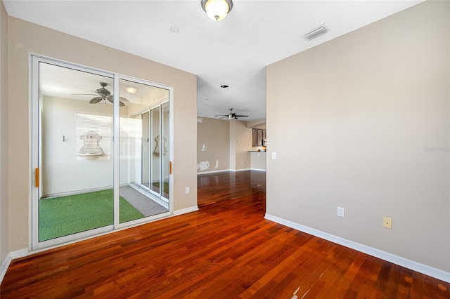 unfurnished room featuring a textured ceiling, dark hardwood / wood-style floors, and ceiling fan