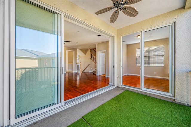 unfurnished sunroom featuring ceiling fan