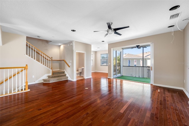 unfurnished living room with dark wood-type flooring, ceiling fan, and a textured ceiling