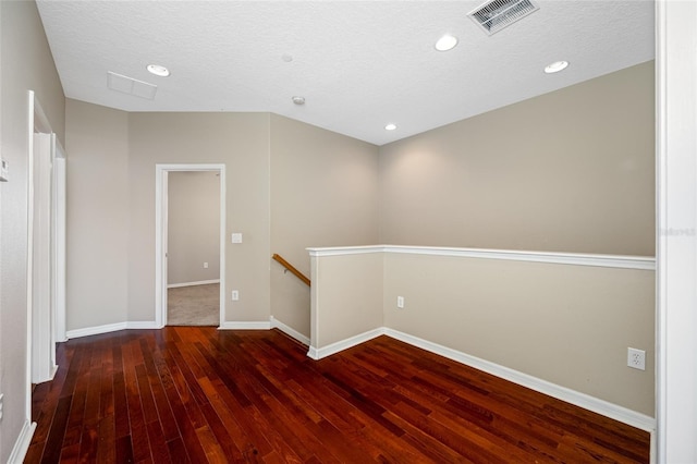 unfurnished room with dark hardwood / wood-style flooring and a textured ceiling