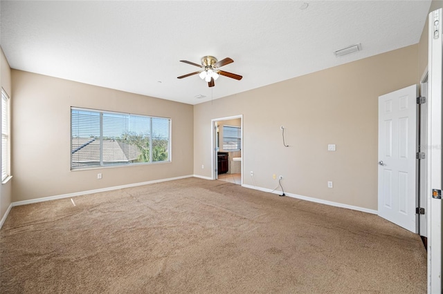 spare room featuring light carpet and ceiling fan