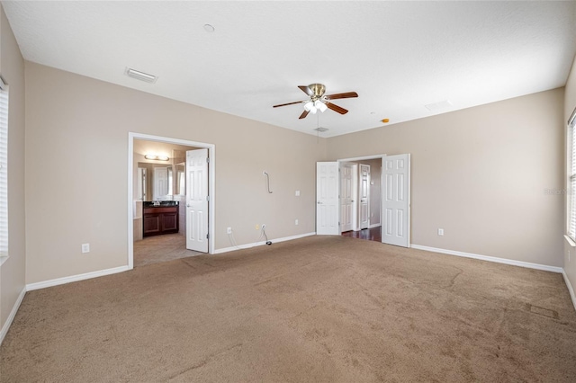 unfurnished bedroom featuring light carpet and connected bathroom