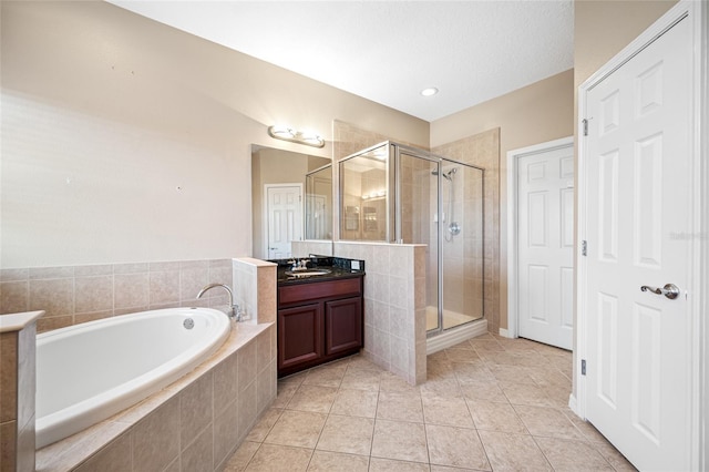 bathroom with tile patterned floors, vanity, and shower with separate bathtub